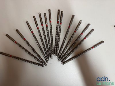 plusieurs types de vis disposés en cercle sur une surface blanche