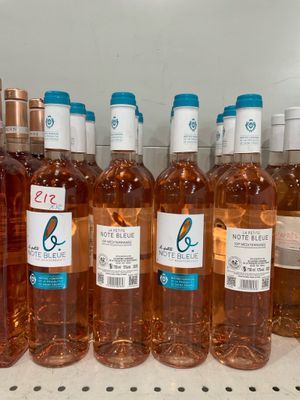 bottles of wine are lined up on a shelf in a refrigerator
