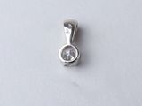 a close up of a small diamond pendant on a white surface