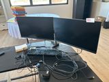 a desk with two monitors and a keyboard on it