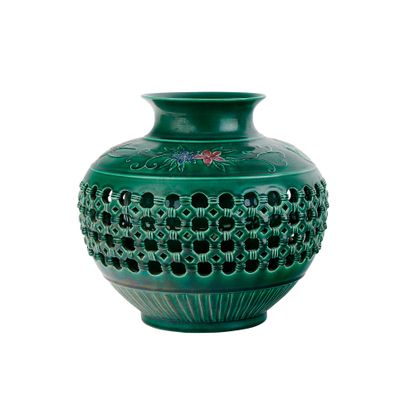 a green vase with holes in it on a white background
