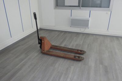 une palette en bois au milieu d'une pièce dotée d'une fenêtre