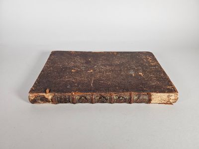 un vieux livre posé sur une table blanche