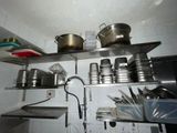 many pots and pans on the shelves in the kitchen