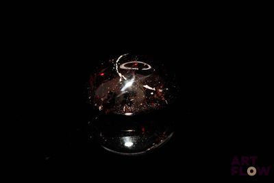 a glass vase with a ring on it sitting on a table