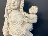 an old statue of a woman holding a baby in her arms