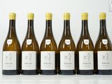 six bouteilles de vin sont alignées sur une table