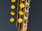 a close up of a guitar neck with yellow knobs on it