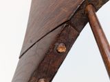 a close up of a wooden chair with a metal handle