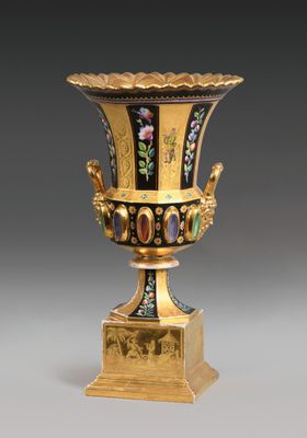 une image représentant un vase noir et doré orné de fleurs