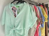 a lot of shirts hanging on a rack in a room