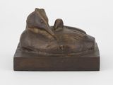 une sculpture en bronze représentant une personne allongée sur un socle en bois