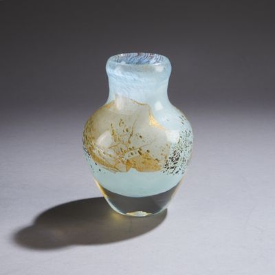 un petit vase en verre posé sur une surface blanche