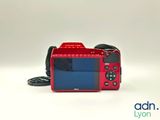 a red camera that is sitting on a white surface