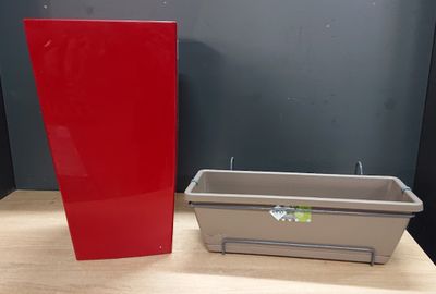 un récipient rouge posé à côté d'un récipient gris sur une table