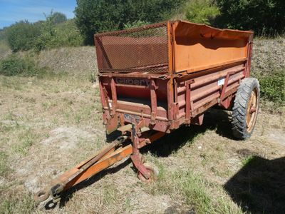 une remorque rouge garée dans l'herbe