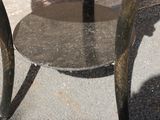 a small table with a glass top on the sidewalk
