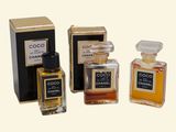 three bottles of perfume sitting next to each other on a white surface