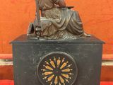 une statue de femme assise au sommet d'une horloge