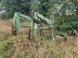 un tracteur vert qui est garé dans l'herbe
