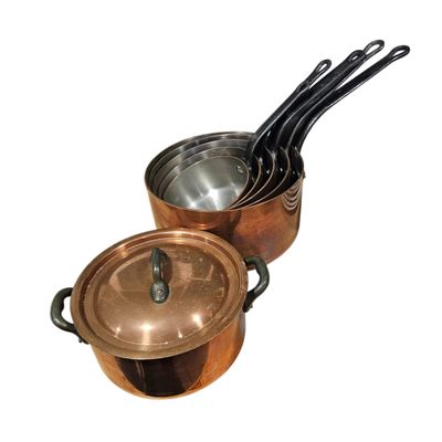 three pots and pans sitting on top of each other on a white surface