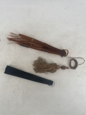 a black umbrella and a brown umbrella on a white surface