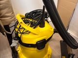 a vacuum that is sitting on the floor next to a chair