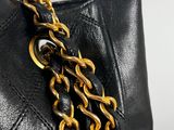 a close up of a black purse with gold chains on it