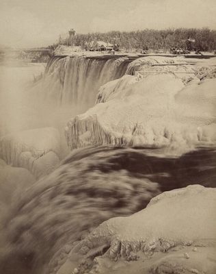 an old black and white photo of a waterfall in the snow
