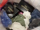 a pile of clothes in a bag with a hat on top