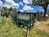 un camion-benne vert garé dans l'herbe