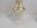 two white and gold vases sitting on top of a white table