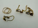 three pairs of gold and silver earrings on a white surface