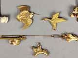 a lot of gold brooches and pins on a table