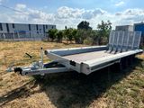 the trailer is parked on the grass in front of a building