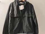 black leather jacket hanging on a hanger in a white room