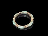 une image représentant une bague en or et en jade sur fond noir