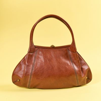 sac à main en cuir marron sur fond jaune
