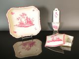 une assiette rose et blanche ornée d'un motif rouge