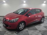une voiture rouge est garée dans une pièce au sol en damier