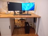 a desk with two monitors and a keyboard on it