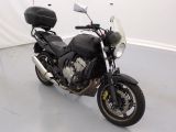 une moto noire garée dans une pièce aux murs blancs