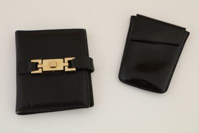 two pieces of black leather with a gold metal clasp on them