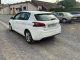 a white car parked in a parking lot next to a house