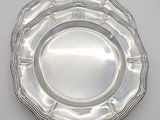 a silver plate on a white table with a crown on it