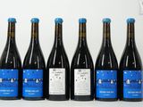 six bottles of wine are lined up in a row on a table