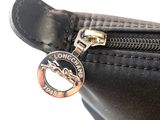 a close up of a black purse with a coin on it