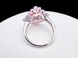 an image of a pink diamond ring sitting on top of a white plate