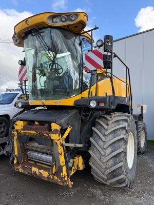 une photo d'un tracteur jaune garé sur un parking