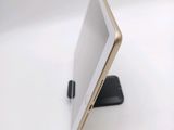 a tablet computer sitting on a stand on a white surface